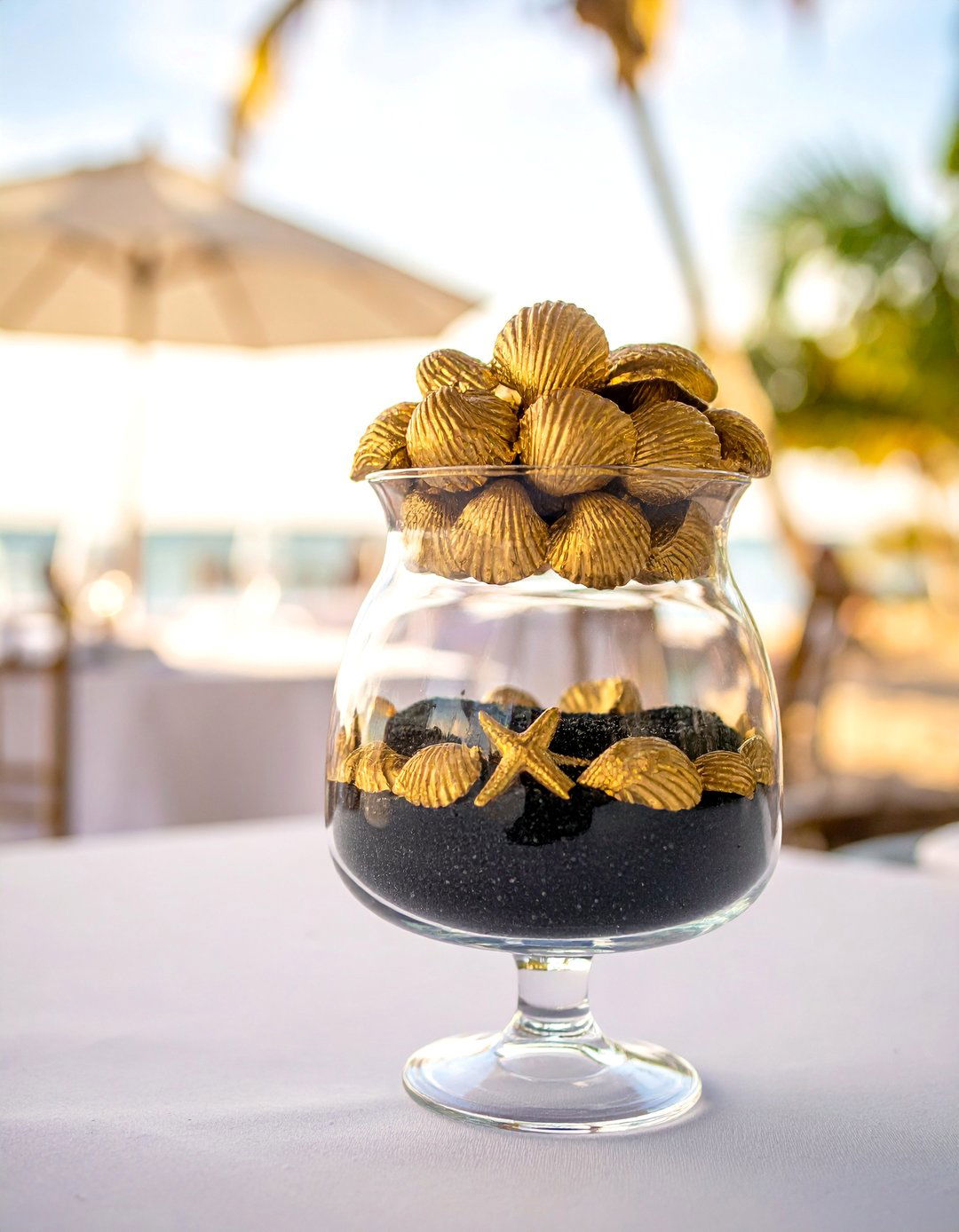 Black Sand and Gold Shells in Glass Jar Centerpiece - 20 Black and Gold Centerpiece Ideas for Elegant Tables